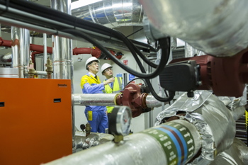 In a busy commercial building, where heating, ventilation and air-conditioning (HVAC) systems are consistently in use, the performance and durability of the pipework connecting system components is paramount to ensure the system’s performance as well as for ensuring the occupant’s health and safety. Exposed to a wide range of stresses, temperatures and pressures, steel tubes used within HVAC and building service applications need to meet specific requirements to ensure their reliability. For example, it is essential to take into account the fluid being conveyed, as this can often contribute to the deterioration of the tube in service. Extremes of acidity or alkalinity or high levels of oxygen within the system can result in corrosion. Furthermore, if high levels of calcium are present — often common in hard-water areas — build up and blockages within the pipework can occur. In such cases it is therefore essential to employ an appropriate fluid treatment in the pipework system. When considering the correct product for a HVAC application, the tube-manufacturing process is often ignored, with other factors such as the material specification or legislative compliance being considered more important. Yet the steel tube’s manufacturing process is actually vitally important in respect of its performance in service. Steel tubes used in building-services applications are normally ordered to BS EN10255, the successor to the old BS1387. However, whilst withdrawn in 2004, BS1387 is still commonly referenced, which can lead to procurement and compliance issues. Tubes to BS EN10255 can be produced by two notably different manufacturing processes — either hot-finished or cold-formed. Welded steel tubes produced in this way have markedly different physical properties which will affect their in-service performance, hence the importance of taking the manufacturing process into consideration. Cold-formed tubes are produced from steel strip that is formed and welded at ambient temperature to produce a cylindrical tube shape. Whilst undergoing this process, the material hardens, due to the cold working and the welding process, resulting in internal stresses being induced in the tube. The main stress occurs in the region adjacent to the weld seam, often referred to as the heat-affected zone (HAZ). Within this region, the steel has a distorted gain structure, caused by the heat input of the welding operation. This makes it harder and less malleable, and any subsequent fabrication or manipulation during installation may further increase the internal stress level, resulting in a greater risk of cracking or of failing in service due to an increased vulnerability to corrosion. Whilst the manufacturing process for hot-finished tubes may appear similar to that of cold formed, it includes one additional vital step that ensures the removal of any internal stresses. This involves induction or furnace heating of the tube to a very high temperature. As the temperature rises, the internal stresses in the steel are relaxed and the distorted grain structure of the heat-affected zone adjacent to the weld line is completely removed. As such, hot-finished tube products offer 10 benefits over their cold-formed counterparts. • A more ordered and consistent microstructure • No internal stress that can promote cracking • More consistent and reliable mechanical properties • Improved structural integrity and ductility • Improved and more consistent toughness • A higher pressure integrity • A greater factor of safety • No loss of strength due to additional welding or heating • An improved performance against corrosion • The ability to be threaded, grooved or bent to tight radii without splitting, creasing or collapsing Using the correct welded steel tube in building-services applications is therefore vital, and for this reason the better durability and reliability offered by hot-finished products should always be considered. Tata Steel’s Install Plus 235 brand, for example, provides a robust solution for such demanding conveyance applications. This multi-certified tube range ensures that each product is aligned with both the CE marking requirements of the Construction Products Regulations (CPR) and also the Pressure Equipment Directive (PED), by manufacturing to both BS EN10255 and BS EN10217 Part 2. It is important to note that only by requesting an BS EN10217 Part 2 product, can you guarantee that a hot-finished or ‘GH’ (Get Hot) steel tube will be supplied. To highlight the importance of tube manufacturing and raise awareness of pipework related issues, Tata Steel, in collaboration with the School of Civil & Building Engineering at Loughborough University, has established the Building & Industrial Services Pipework Academy (BISPA). This supports the building and industrial services industry by offering training courses and CPD programmes focused on a range of industry issues, including tube specifications and the benefits of hot-finished products. Therefore, when considering what tube to use for a building-services application, looking beyond the specification to the manufacturing process is strongly recommended. Remember, not all steel tubes are the same. Hot-finished steel tubes can provide an unparalleled level of reliability and durability within pipework systems, delivering safety and performance benefits as well as a longer life. Stewart Jones is senior customer technical services field engineer for conveyance tubes at Tata Steel.